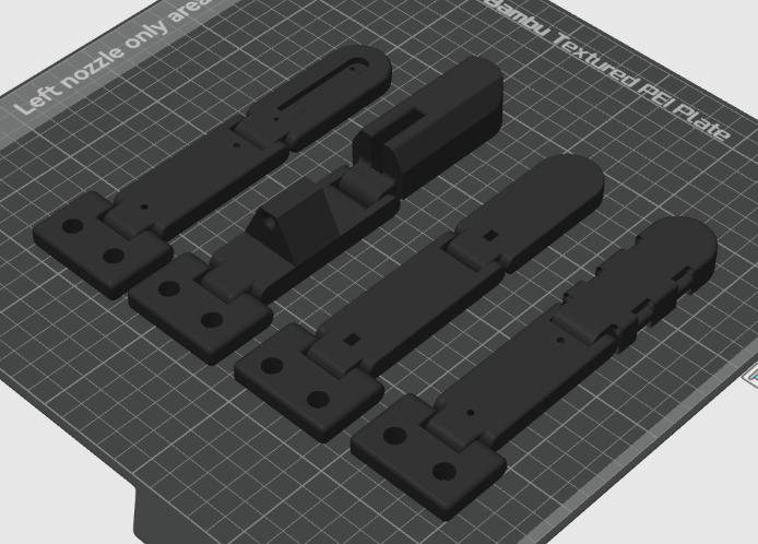 Four black 3D-printed finger designs side by side on a printer build plate